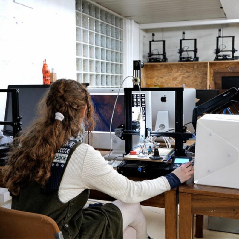 Statue d’homme assis en art public moderne, matériaux composites, style urbain et conceptuel, intégrant l’environnement